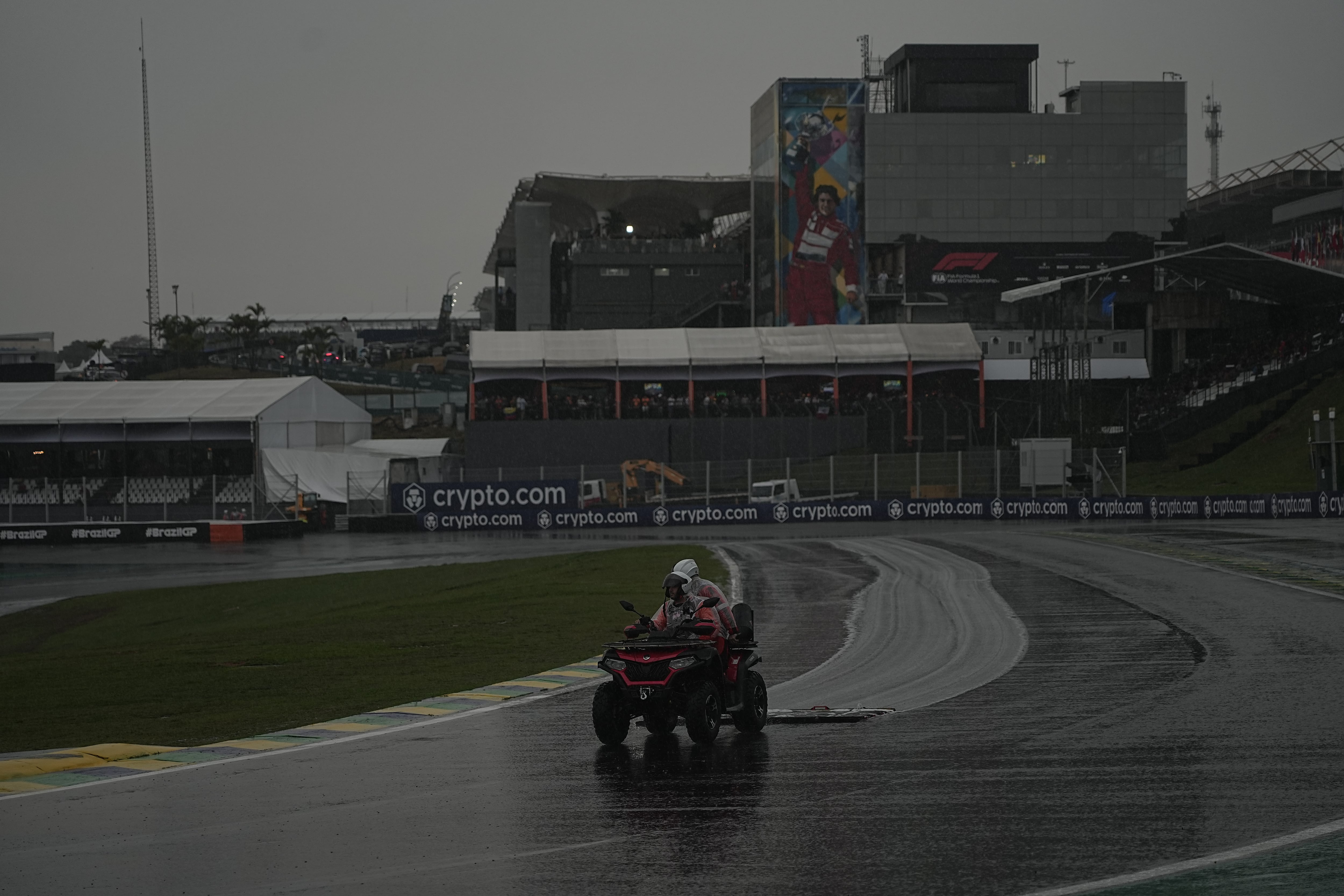 Operarios del circuito tratando de secar la pista.