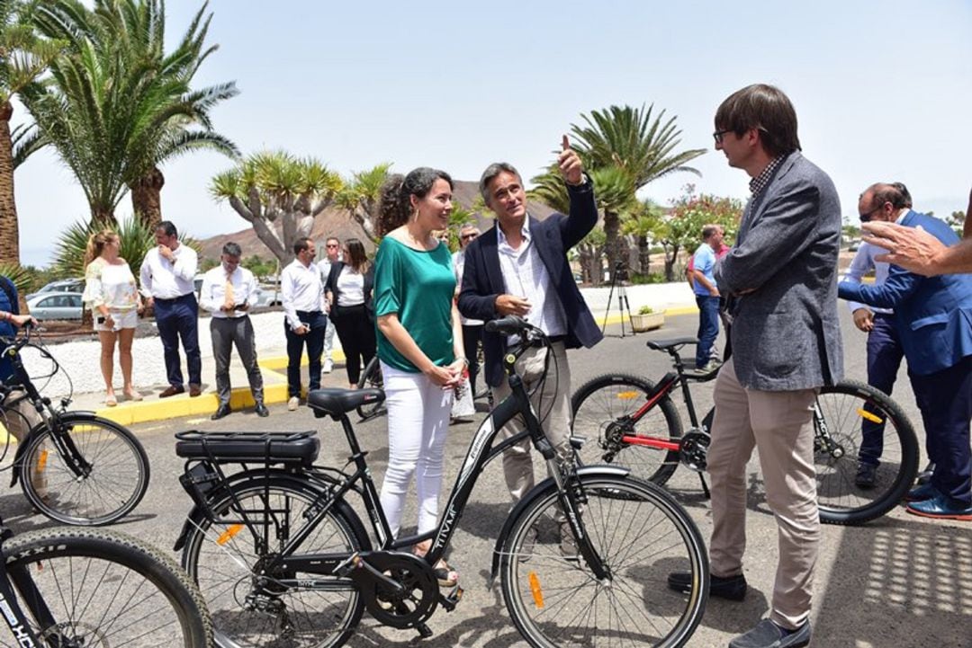 La consejera de Energía, Ariagona González, escucha las explicaciones sobre el servicio de alquiler de bicicletas eléctricas.