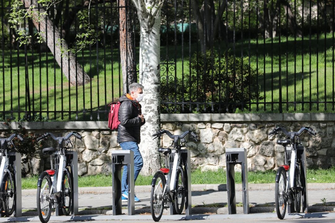 Un hombre pasa junto a bicicletas de BiciMAD. 