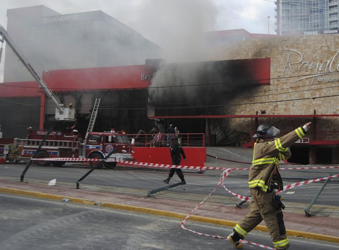 Bomberos tratan de apagar un incendio tras el ataque con una granada contra el Casino Royal en Monterrey (México)