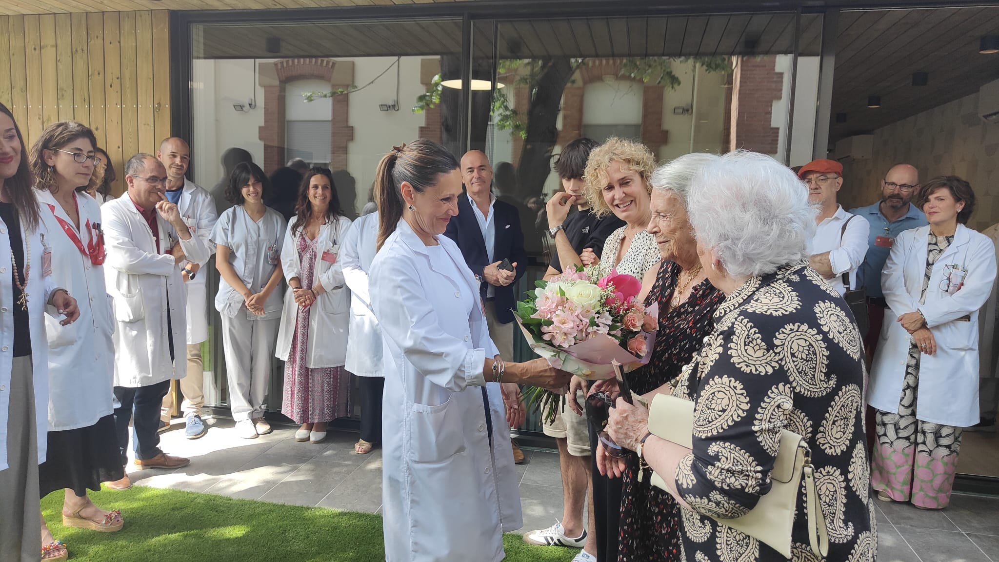 La madre de María Zandio recibe el ramo en la inauguración del nuevo espacio que Hospitalización Psiquiátrica Infantojuvenil.