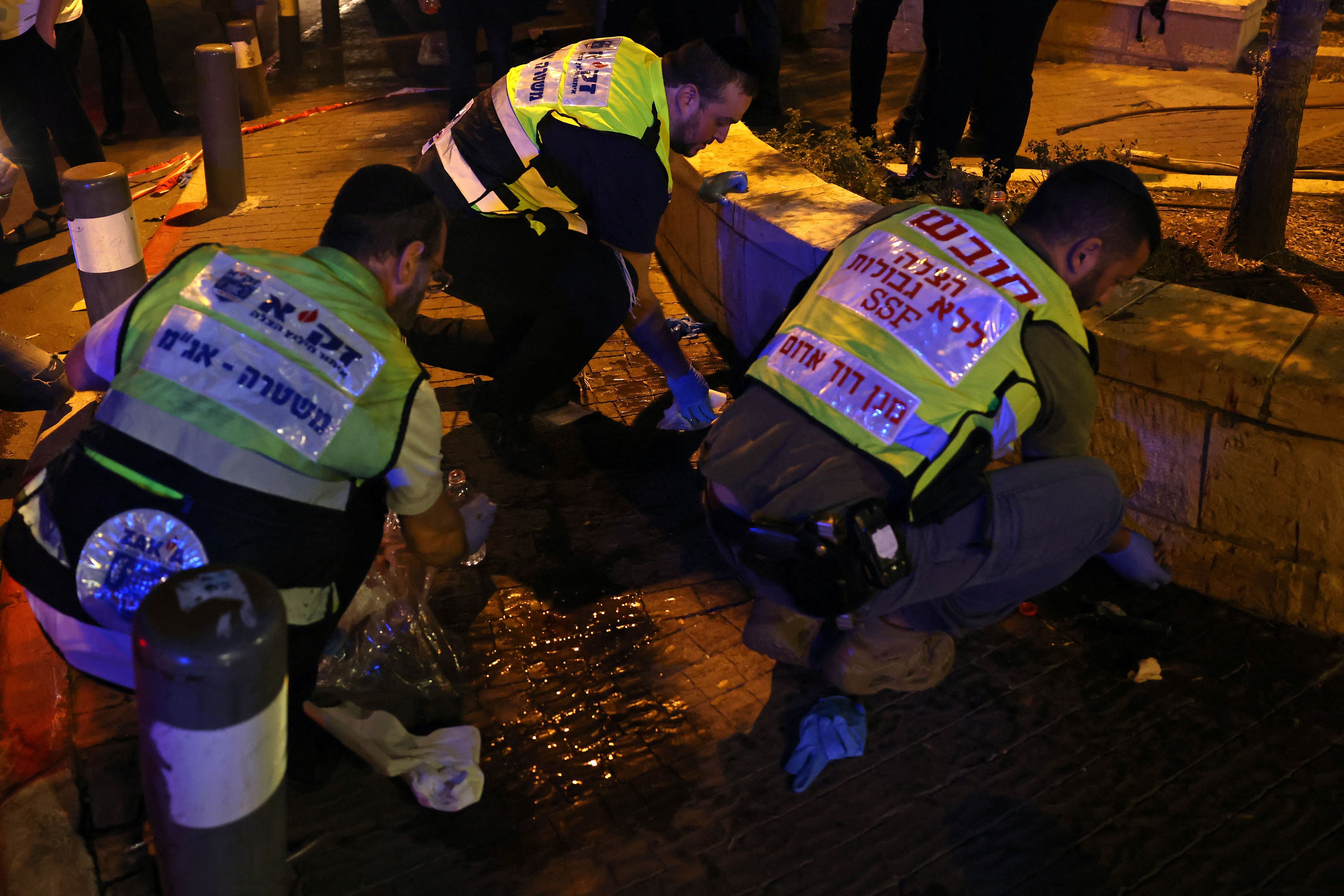 Los voluntarios de Zaka, un equipo de respuesta de emergencia judío ultraortodoxo, limpian las manchas de sangre después de un ataque en las afueras de la Ciudad Vieja de Jerusalén