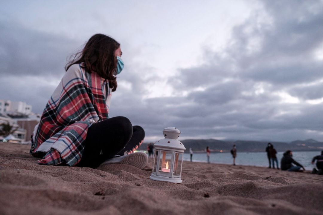  Un grupo de personas se ha concentrado este martes en la orilla de la playa de Las Canteras, en Las Palmas de Gran Canaria, para participar en un duelo por la niña de Mali que falleció este domingo, tras haber sido rescatada cinco días antes en estado cr