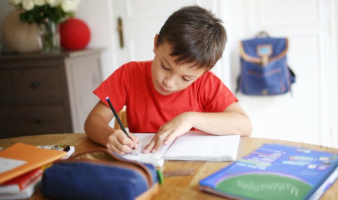 Niño de 7 años haciendo uso de libros de texto