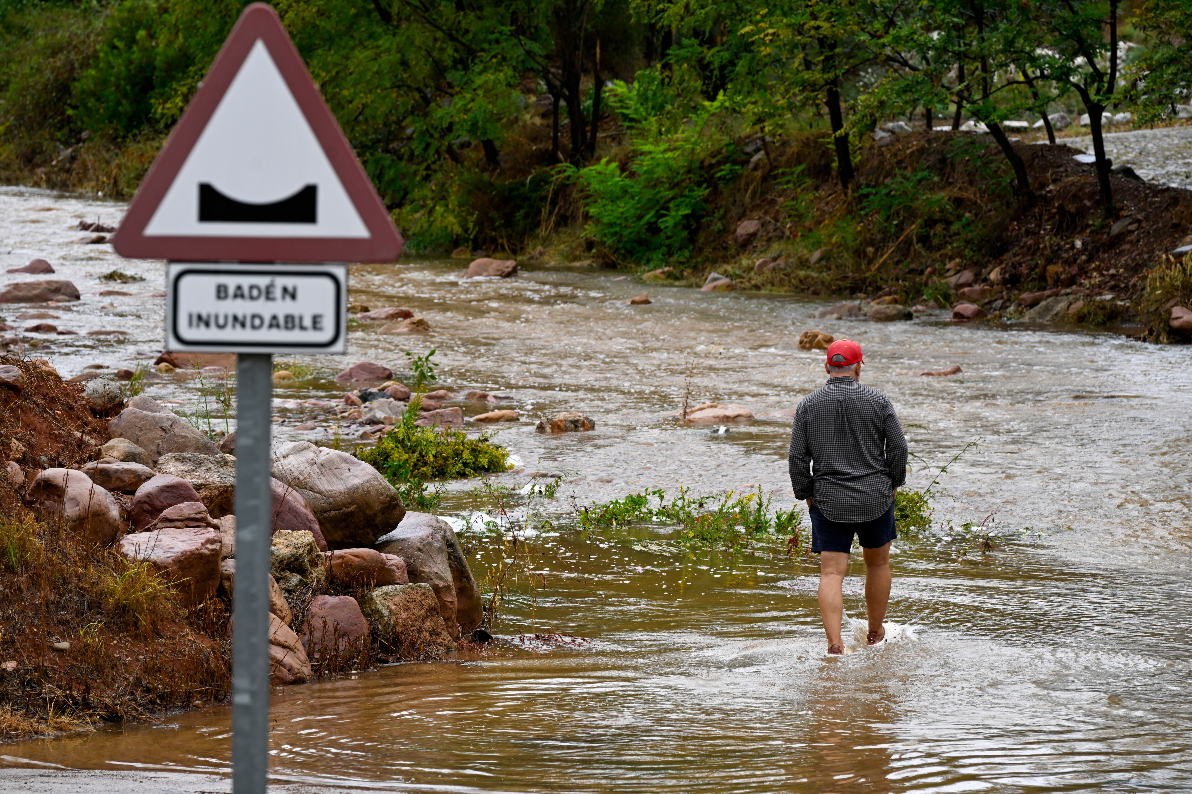 GRAFCVA9471. ARTANA (CASTELLÓN), 29/09/2025.- Un hombre cruza un badén inundable durante este lunes. EFE/Andreu Esteban