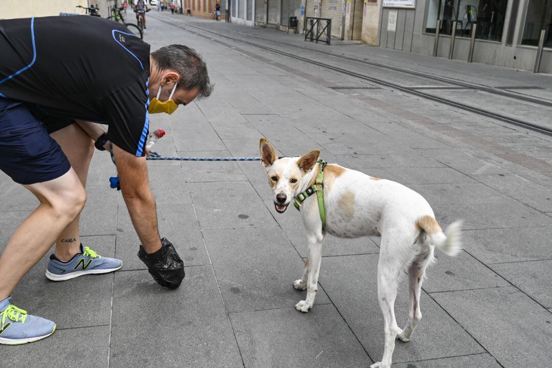 Un vecino limpia los excrementos de su perro