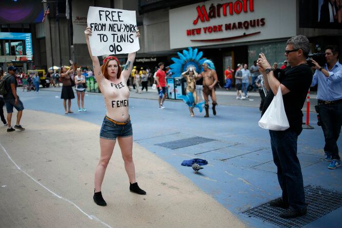 Constantin, una activista de FEMEN, sostiene un cartel durante una protesta en &#039;topless&#039; en Nueva York