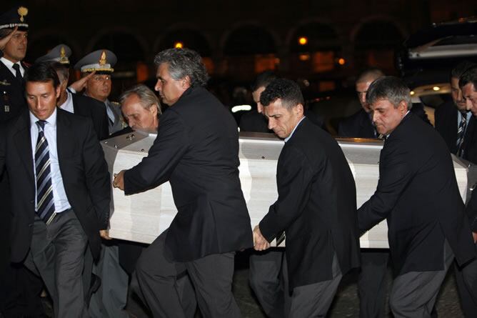 Varios hombres portan el ataúd de Pavarotti