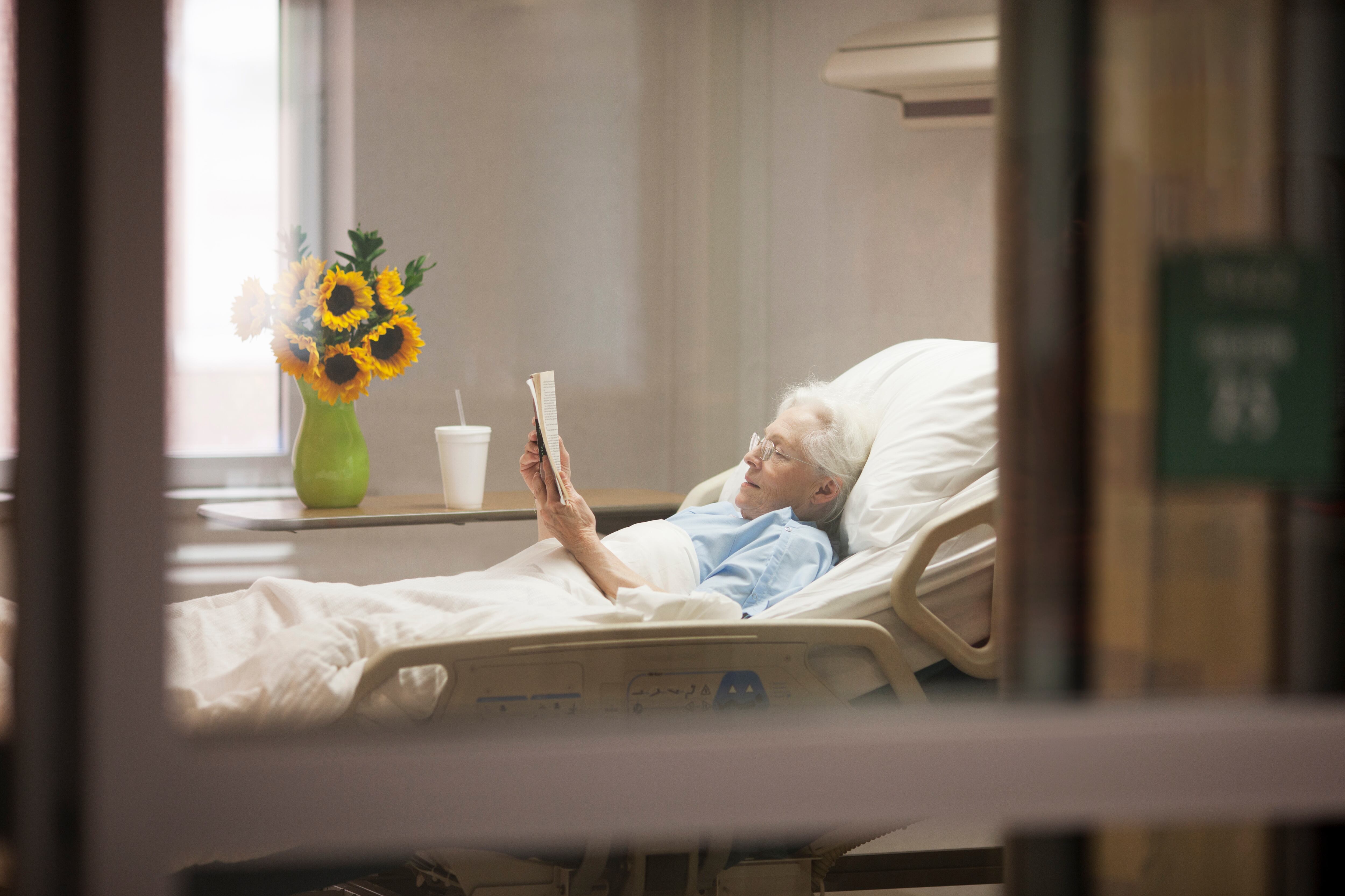 Una mujer leyendo un libro en el hospital.