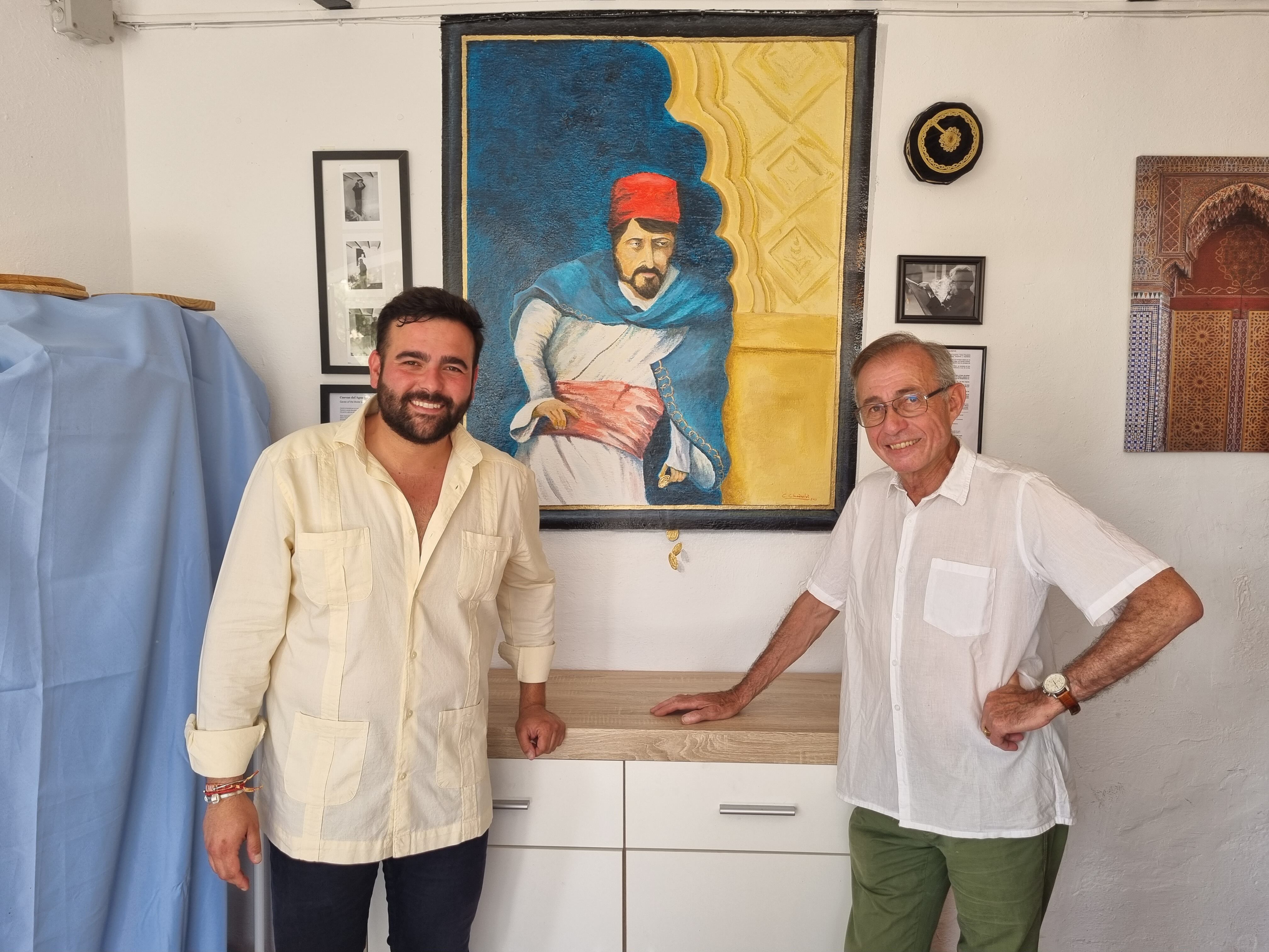 El pintor Carlos Chauderlot y el responsable del establecimiento, Javier Osuna, posan junto al mural