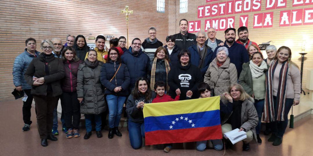 El sacerdote Samuel Pérez, con abrigo azul y sonriendo, junto con sus compatriotas venezolanos en su parroquia de Cristo Rey en el barrio de las Fuentes de Zaragoza