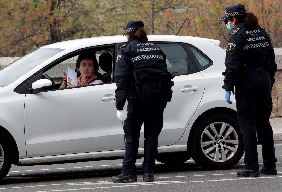 Dos agentes de la Policía Local de Valencia preguntan a una conductora por el motivo para desplazarse en uno de los controles