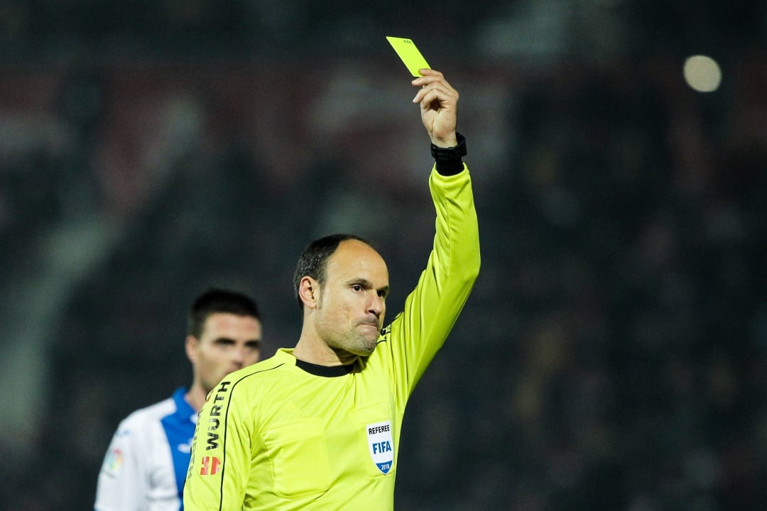 Mateu Lahoz, mostrando una tarjeta amarilla durante La Liga Santander