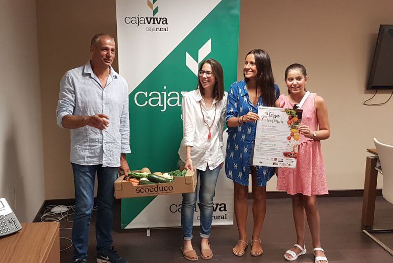 El alcalde de Cuéllar, José María Pilar, y Lourdes García de Ecoeduco sujetan una caja de productos ecológicos en presencia de Beatriz Serrano de la Fundación Caja Rural