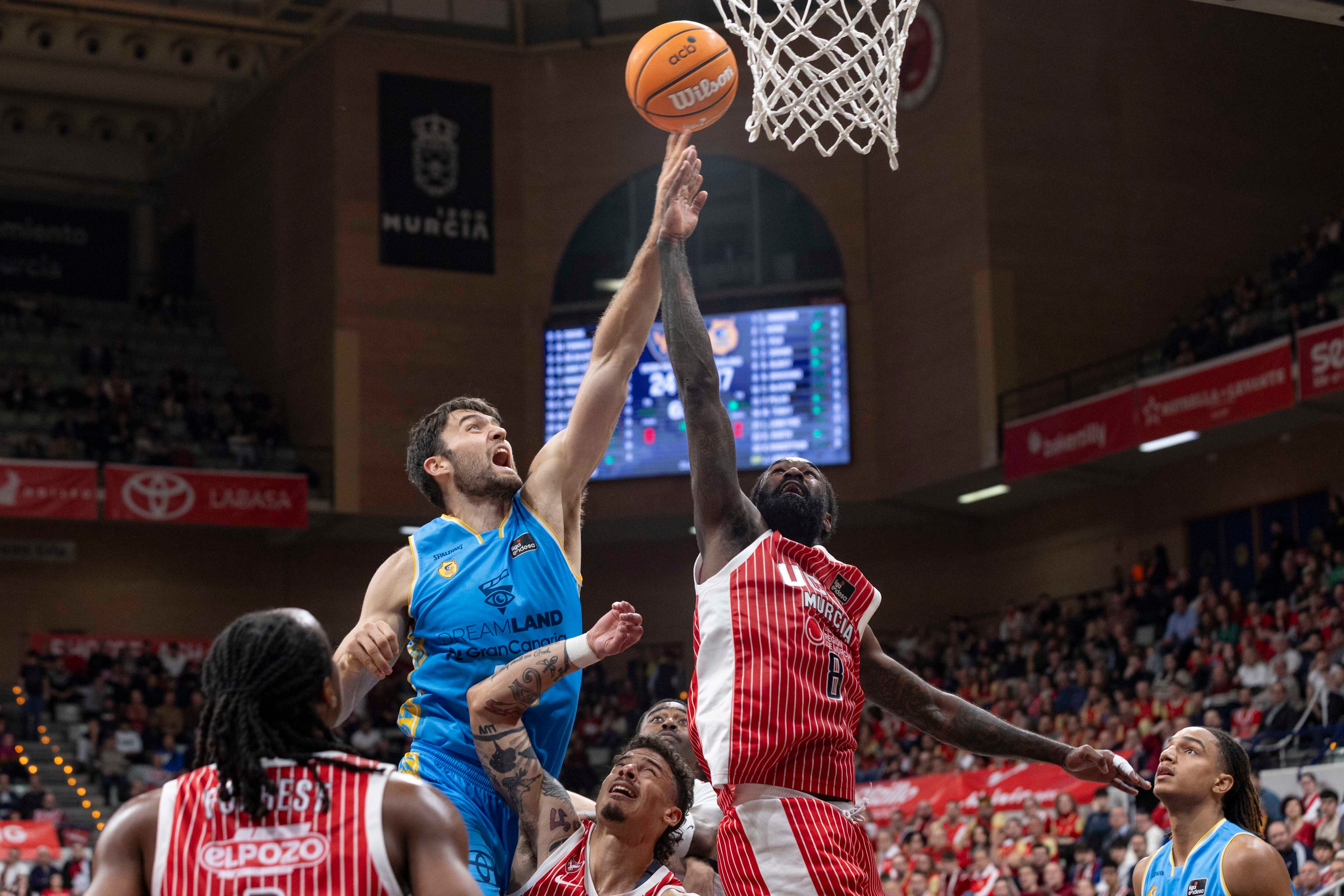MURCIA, 14/03/2026.- El pívot eslovaco de Dreamland Gran Canaria Mike Tobey (i) lucha por el balón con el escolta cubano de UCAM Murcia Howard Sant-Roos (2d), durante el partido de la vigésima segunda jornada de la Liga Endesa que están disputando este sábado en el Palacio de los Deportes de Murcia. EFE/Marcial Guillén