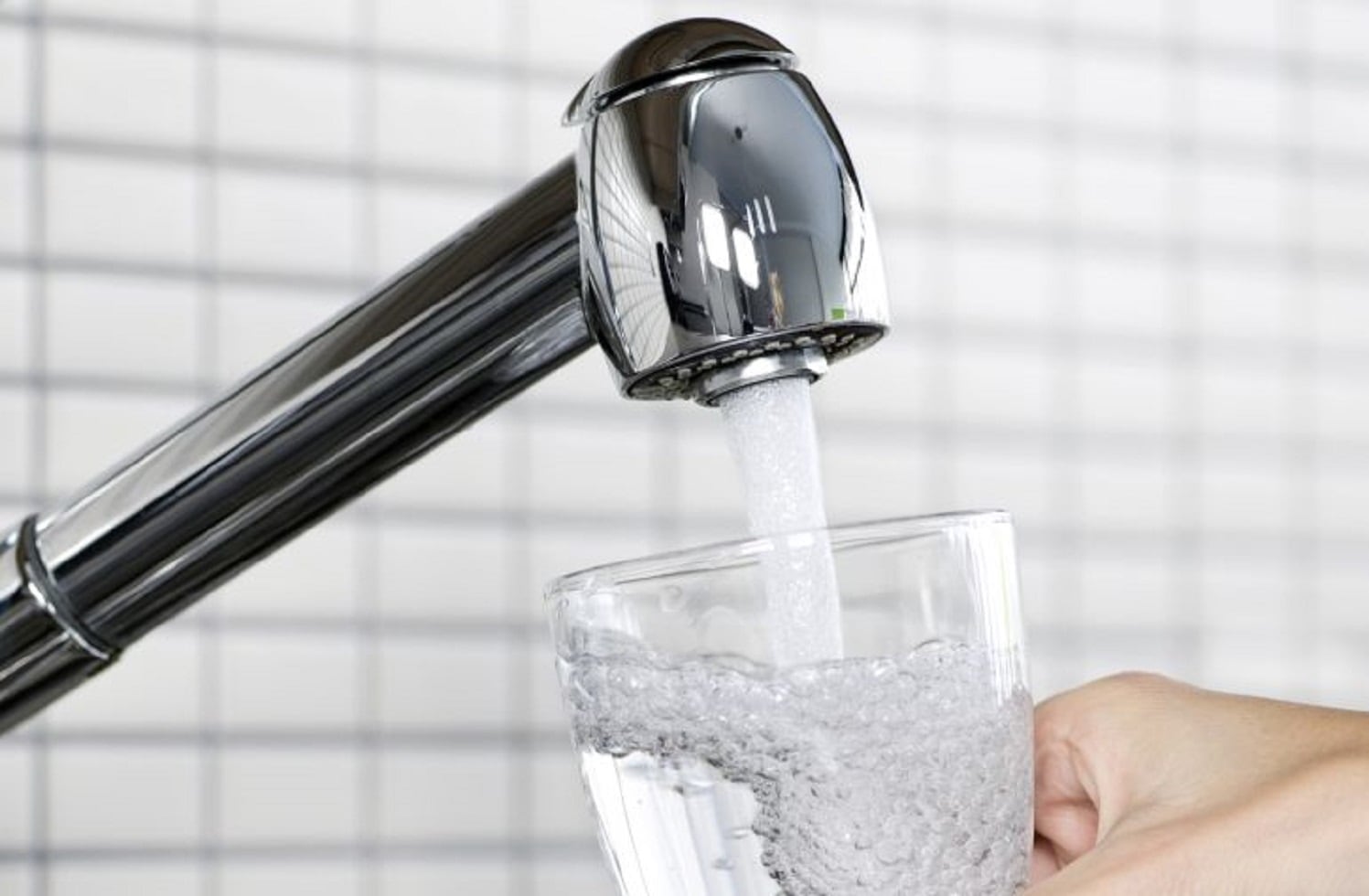 Imagen de archivo de un grifo y un vaso llenándose de agua