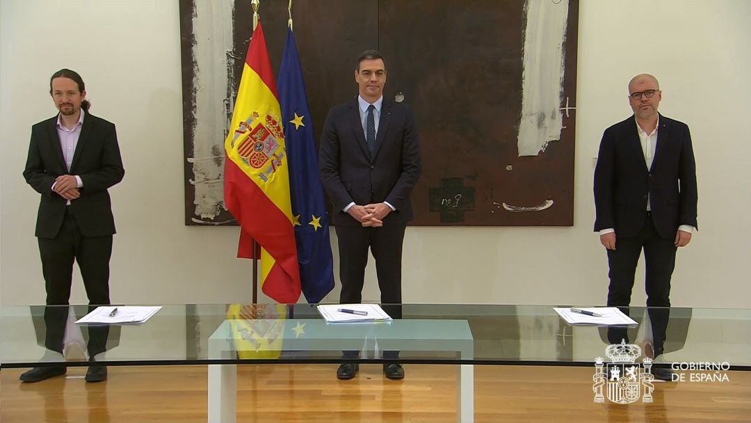 Captura de la señal institucional de Moncloa que muestra (de i a d) al ministro de Derechos Sociales y Agenda 2030 Pablo Iglesias, el presidente del Gobierno Pedro Sánchez y el secretario general de CCOO Unai Sordo durante la firma, este lunes, con los líderes de las patronales CEOE y Cepyme y de los sindicatos UGT y CCOO del pacto que alcanzaron la pasada semana para prorrogar los expedientes de regulación temporal de empleo (ERTE) más allá de la vigencia del estado de alarma. 