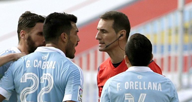 Los jugadores del Celta, el argentino Gustavo Cabral  y el chileno Fabián Orellana, protestan al árbitro Clos Gómez