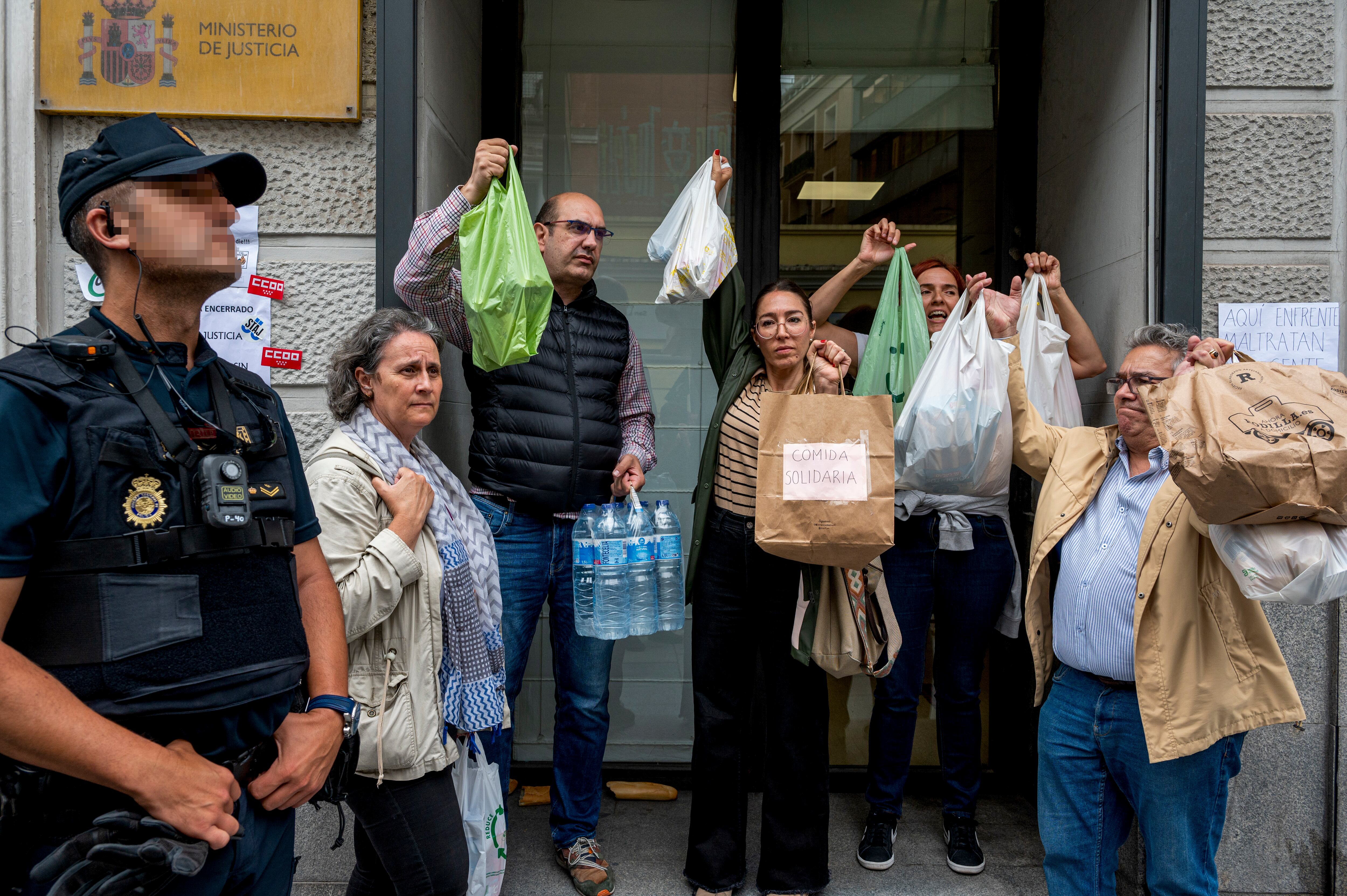 MADRID, 08/06/2023.- Varias personas intentan hacer llegar comida a los representantes de los sindicatos de Justicia encerrados en el Ministerio para exigir que se retomen las negociaciones este jueves frente en el ministerio de Justicia en Madrid. Cinco miembros del comité de huelga de los funcionarios de Justicia mantienen este jueves el encierro que iniciaron en la tarde del martes pasado en el Ministerio para forzar una negociación de sus reivindicaciones de mejoras retributivas y de condiciones de trabajo. EFE/ Fernando Villar
