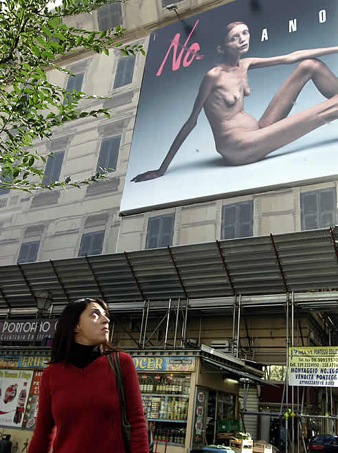 Una mujer mira el anuncio con la fotografía de la modelo anoréxica realizada por Oliviero Toscani.