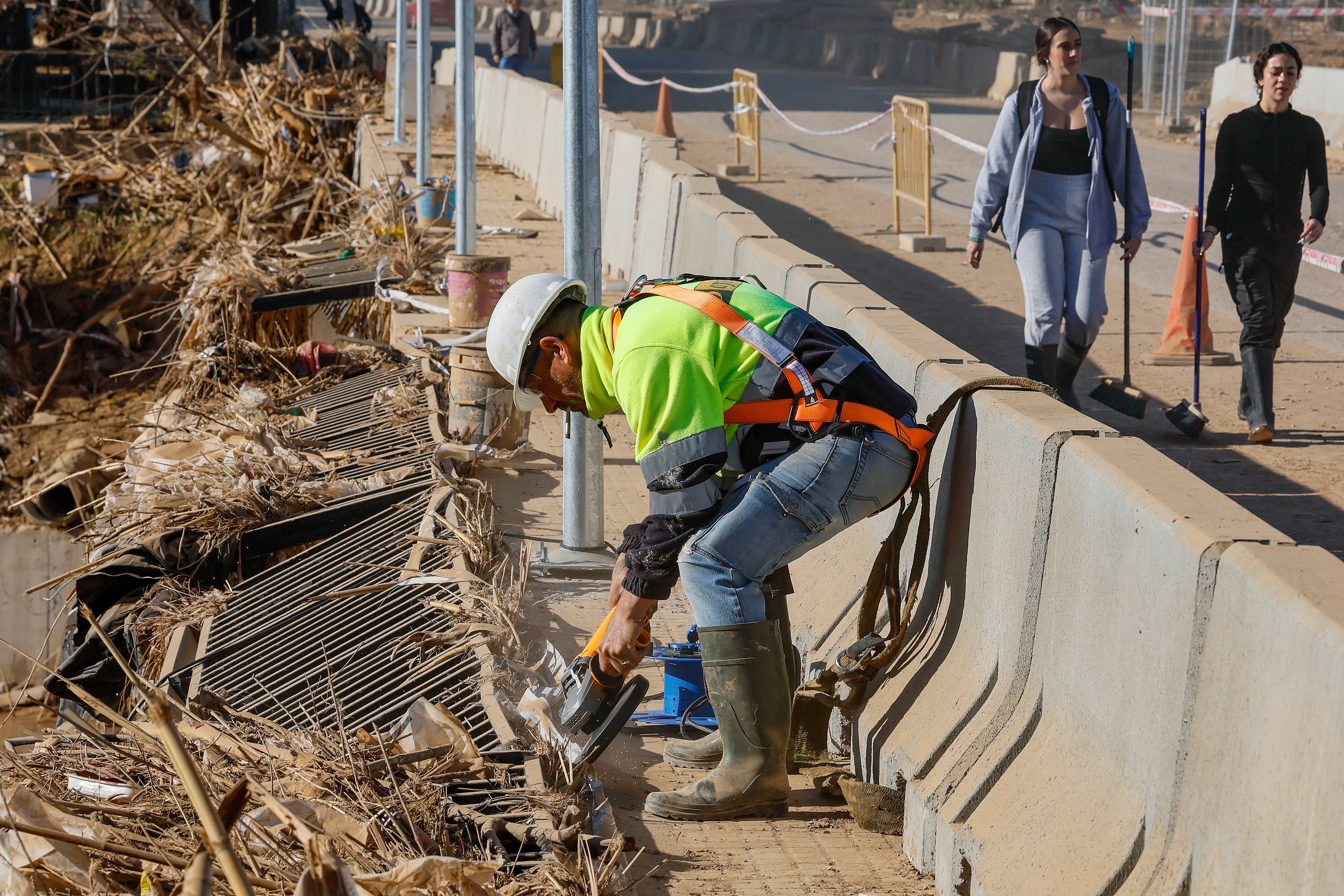 PAIPORTA (VALENCIA), 28/11/2024.- Un trabajador corta con una radial la barandilla metalica de uno de los puentes de Paiporta que fue destrozado por la riada, cuando se va a cumplir casi un mes de la DANA que arraso la zona. EFE/José Manuel Vidal
