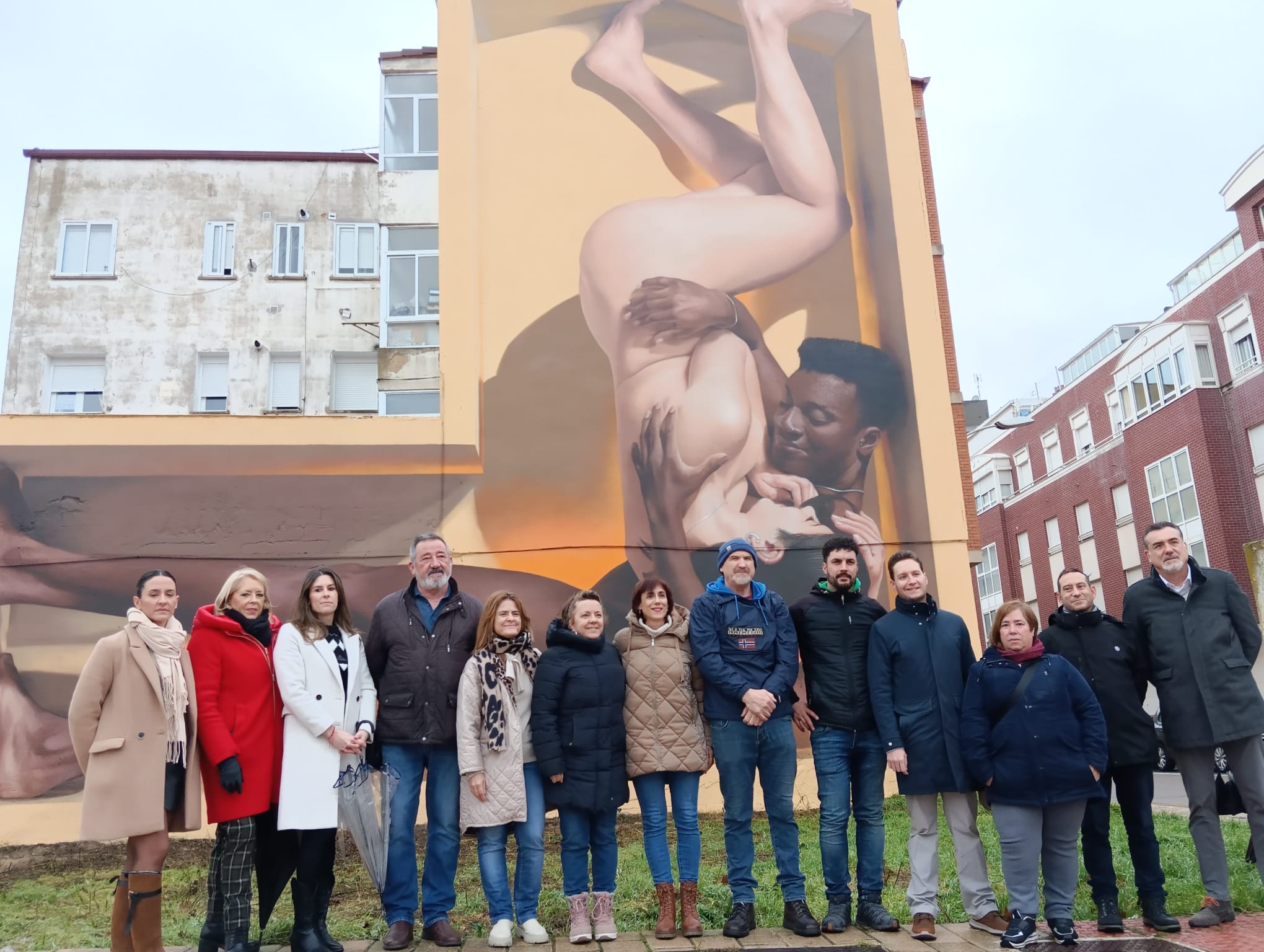 Varios concejales, miembros de la asociación de comerciantes del barrio y el autor del mural posan delante de esta obra de arte urbano