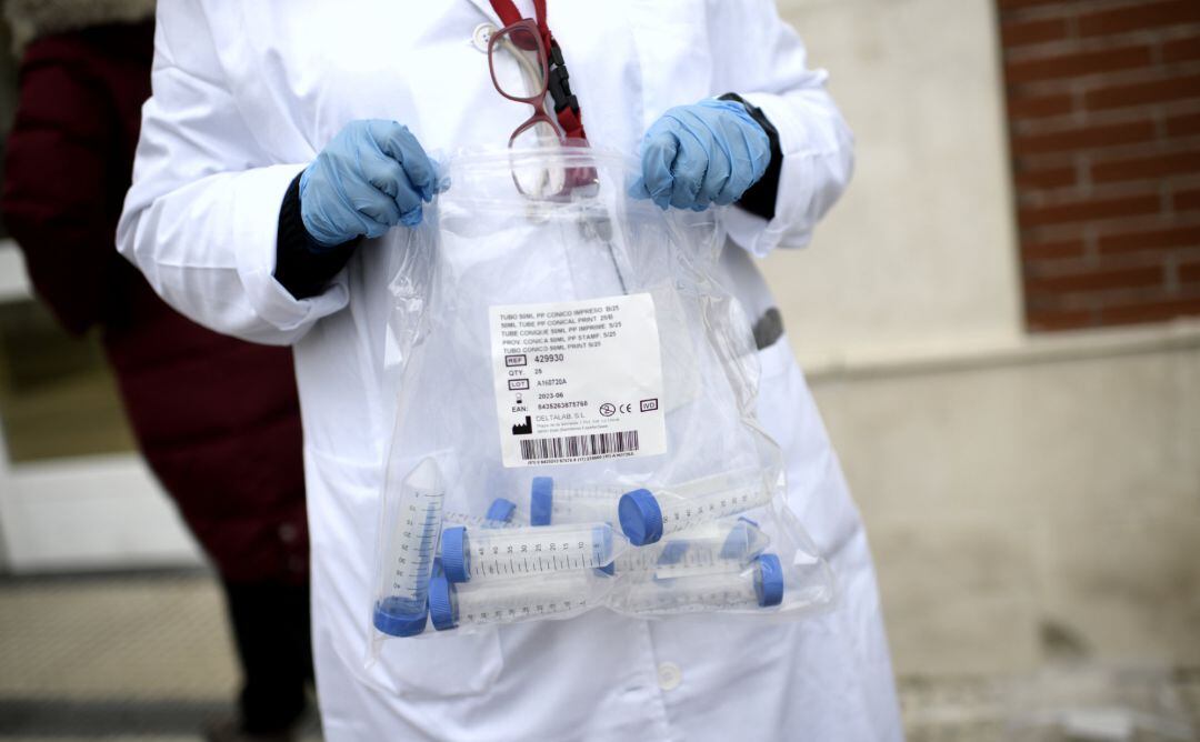 Un sanitario con tubos de ensayo durante la realización de tests de RT-PCR