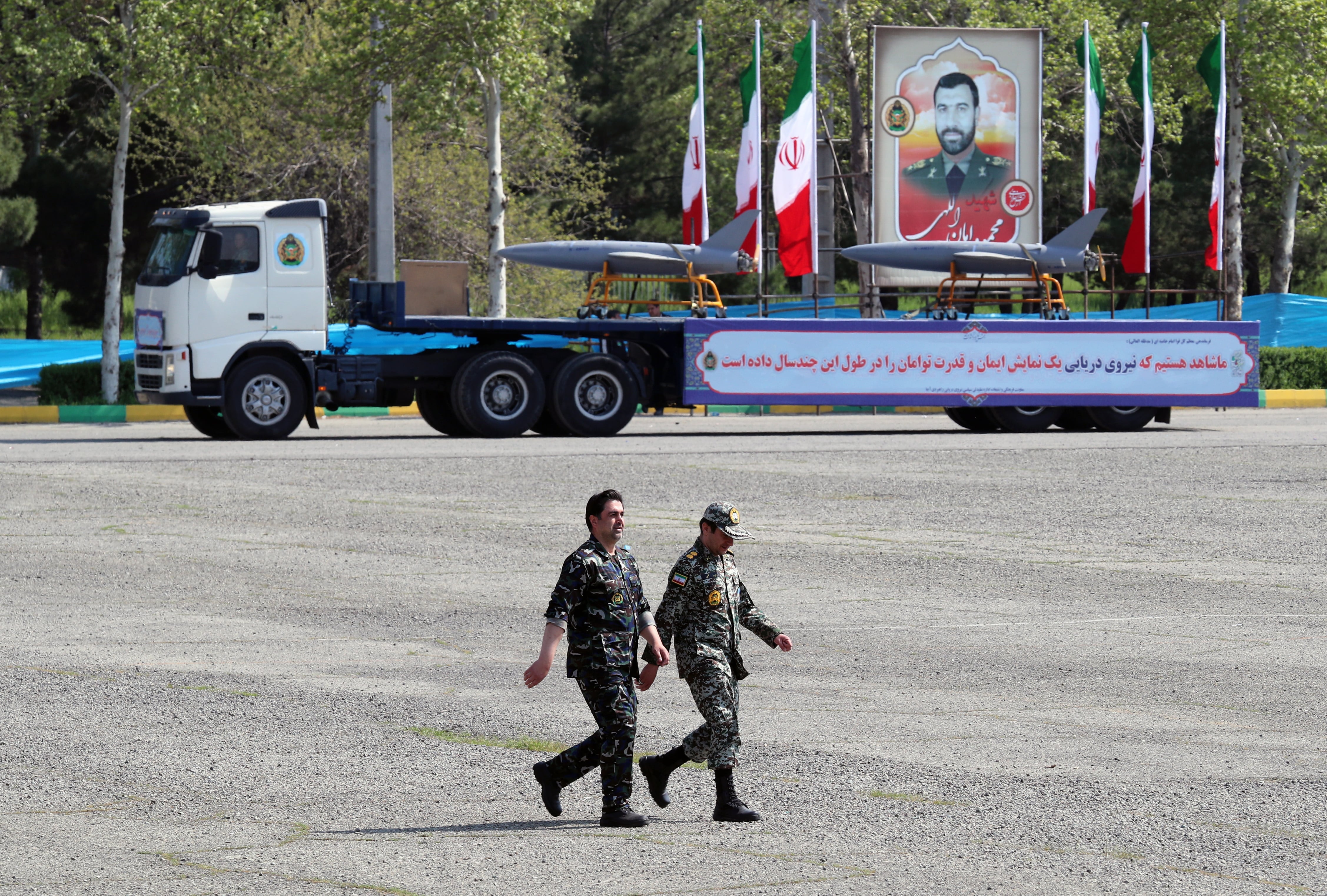 Soldados iraníes caminan cerca de drones cargados en un camión durante la celebración anual del Día del Ejército