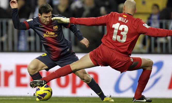 El delantero argentino del Barcelona Lionel Messi consigue el primer gol para su equipo tras regatear al guardameta argentino del Málaga, Wilfredo Daniel Caballero durante el partido que enfrenta a ambos equipos en la decimonovena jornada de la Liga de Pr