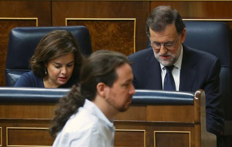 Pablo Iglesias se dirige a la tribuna del Congreso ante el escaño de Soraya Sáenz de Santamaría y Mariano Rajoy