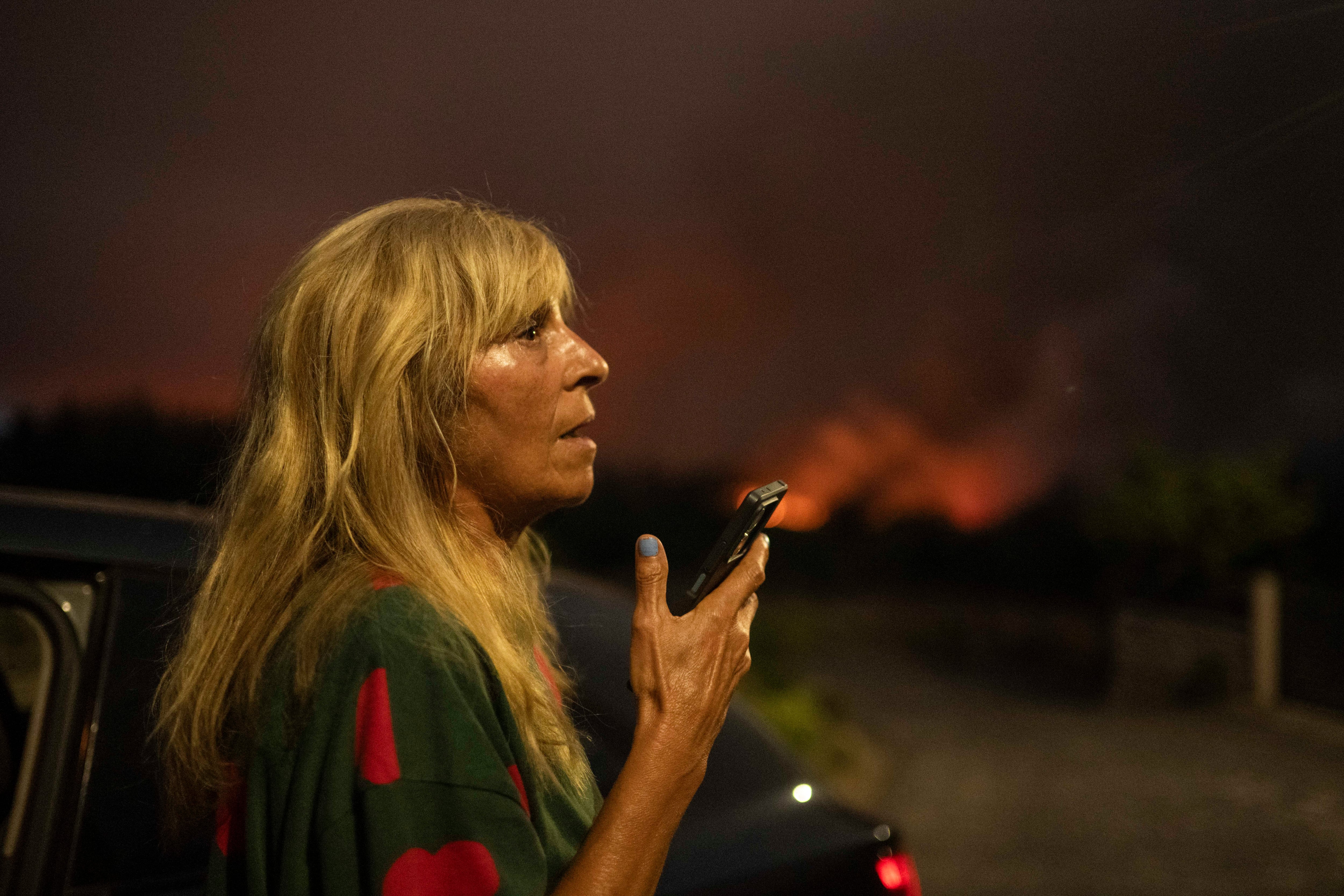 CARBALLEDA DE AVIA (OURENSE), 16/08/2025.- Una mujer pide ayuda por teléfono ante el avance del incendio forestal en Carballeda de Avia (Ourense). EFE/ Brais Lorenzo