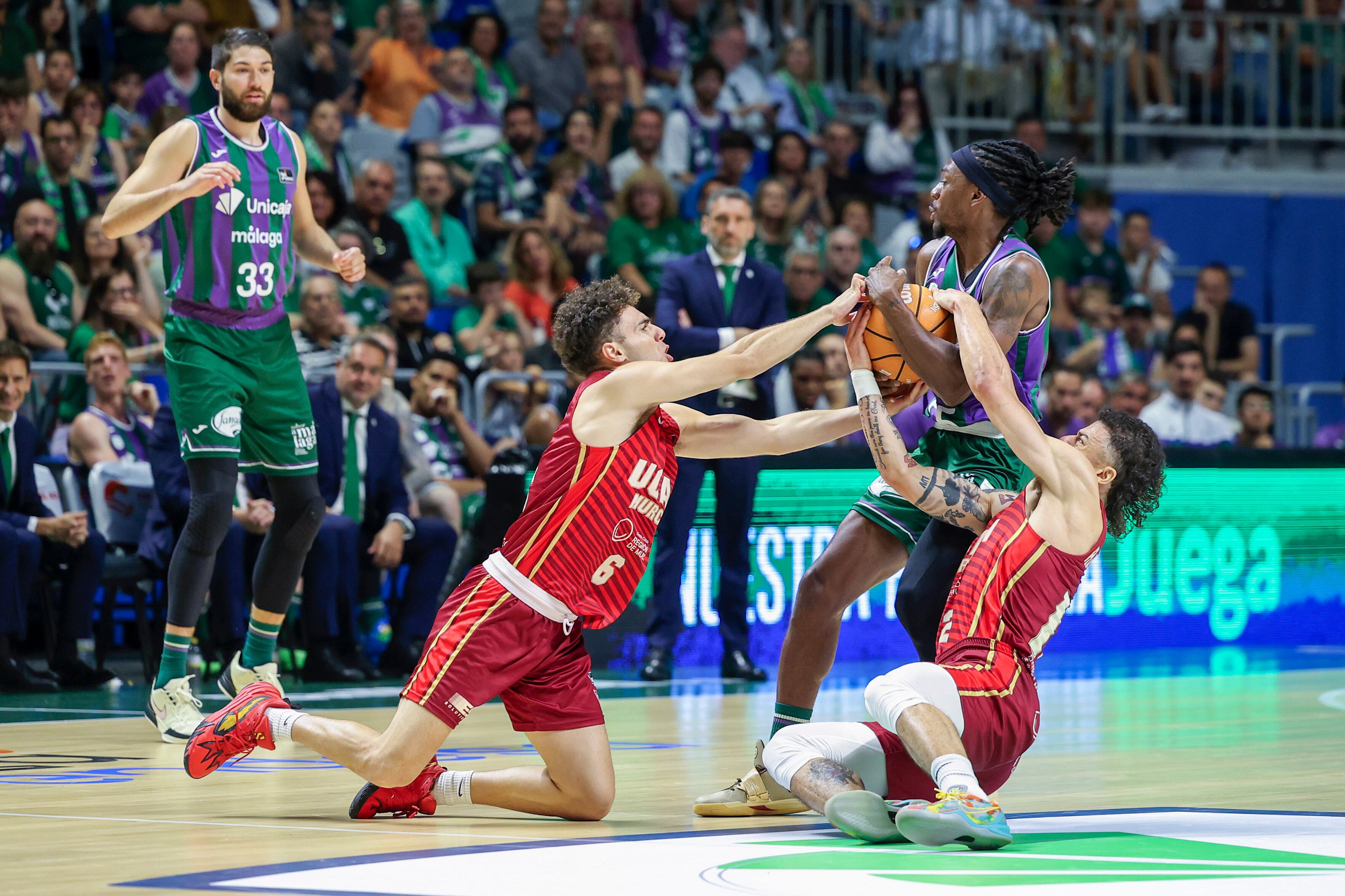 MÁLAGA, 18/05/2025.- Los jugadores García (i), y Radebaugh (d), del UCAM Murcia, disputan un balón a Perry, del Unicaja, durante un momento del partido de baloncesto de Liga Endesa (ACB) que enfrenta al Unicaja y al UCAM Murcia en el Palacio de los Deportes ?José María Martín Carpena de Málaga este domingo. ?EFE/ Daniel Pérez