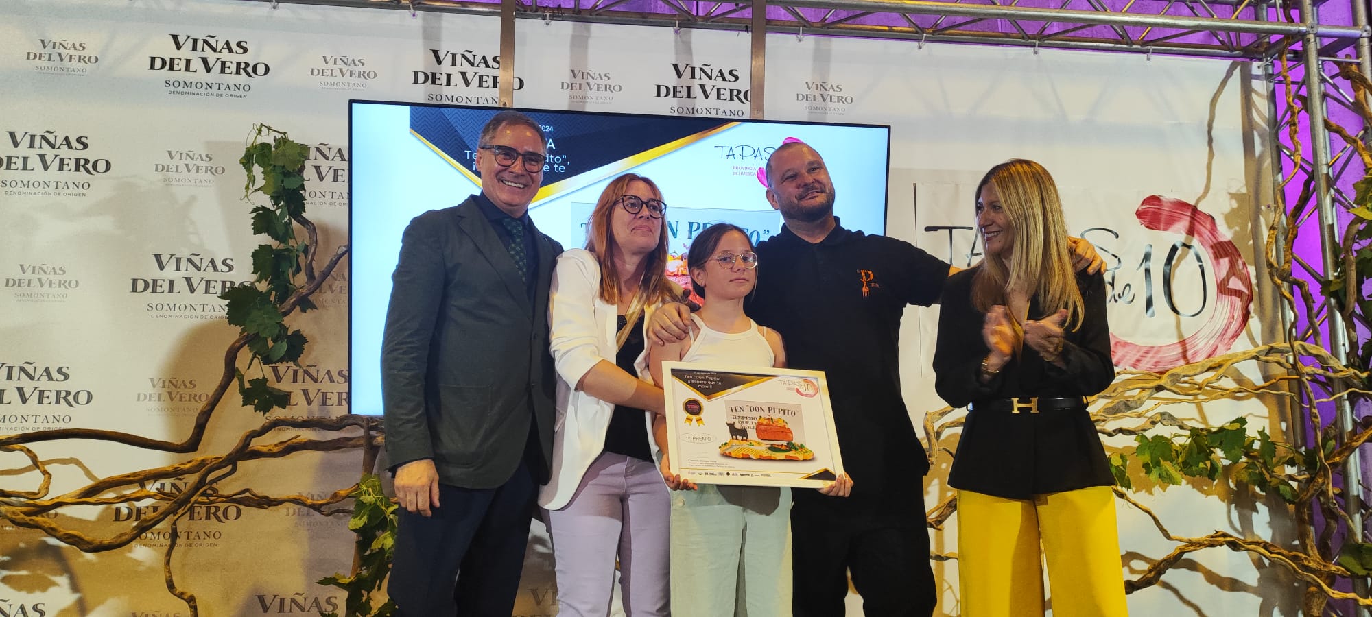 La vicepresidenta y consejera de Economía del Gobierno aragonés, Mar Vaquero, aplaude a Ramón Lapuyade y su familia en presencia de Carmelo Bosque en la entrega de premios del XII Concurso Provincial de Tapas de Huesca