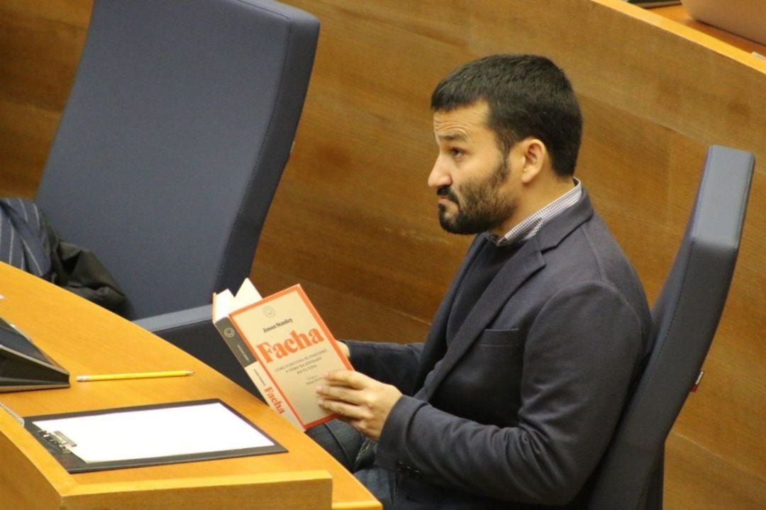 El conseller de Educación, Cultura y Deporte de la Generalitat Valenciana, Vicent Marzà, lee el libro 'Facha' durante una intervención de un diputado de Vox en Les Corts Valencianes