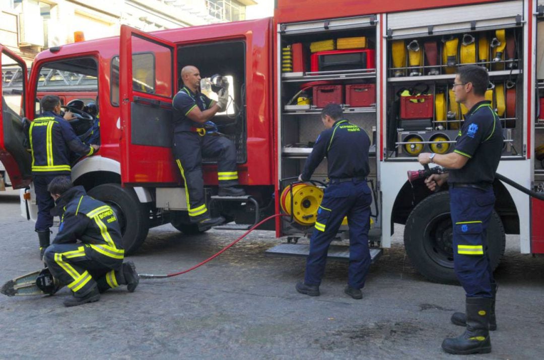 Dotación de bomberos revisando el material de trabajo