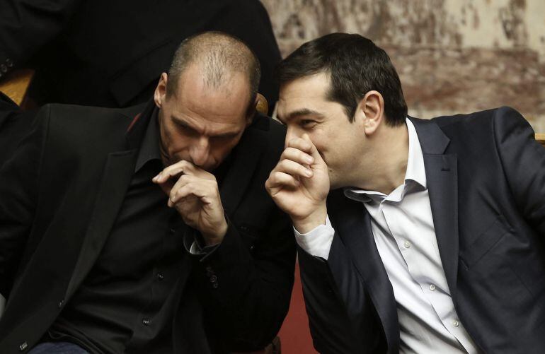 YAN02. ATENAS (GRECIA), 18/02/2015.- El primer ministro griego Alexis Tsipras (dcha) conversa con el ministro de Finanzas Yanis Varufakis durante la votación para elegir al nuevo presidente griego en el Parlamento de Atenas, Grecia, el 18 de febrero del 2