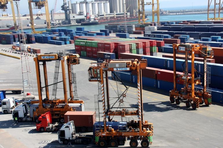 Grues transportant contenidors a la zona de càrrega de mercaderies del Port de Barcelona