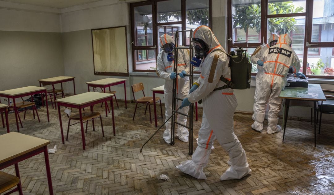 Personal del ejército portugués con equipo de protección desinfecta las aulas de un instituto de Amadora (Portugal)