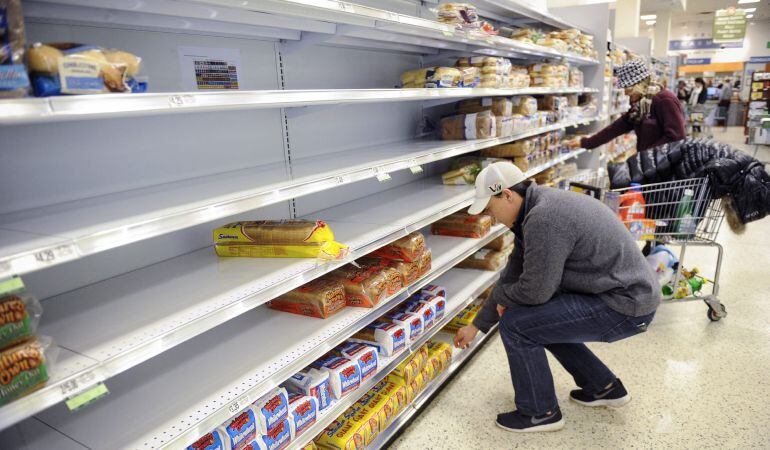 Varias personas hacen la compra en un supermercado