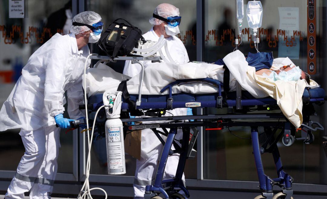 Dos médicos atienden a un paciente.