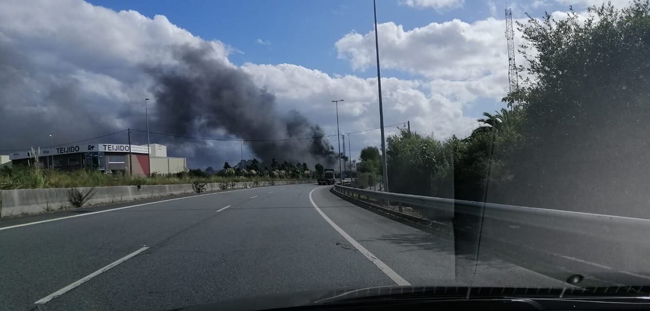 La columna de humo por el incendio, desde uno de los viales del polígono