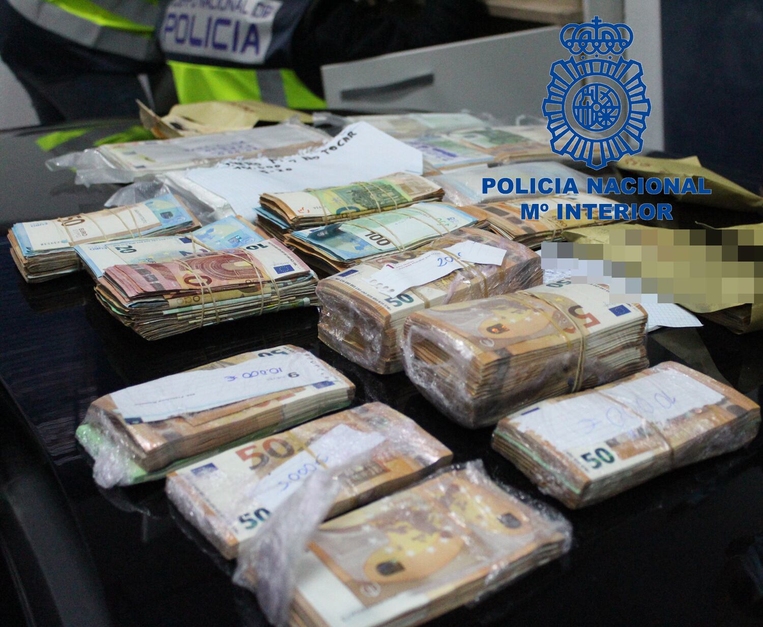 Imagen de la Policia Nacional de los fajos de billetes incautados en la operación