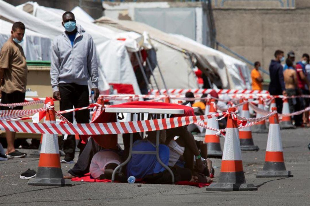 Migrantes aguardan en el muelle de Arguineguín a ser alojados en algunos de los apartamentos habilitados en Gran Canaria para que pasen la cuarentena