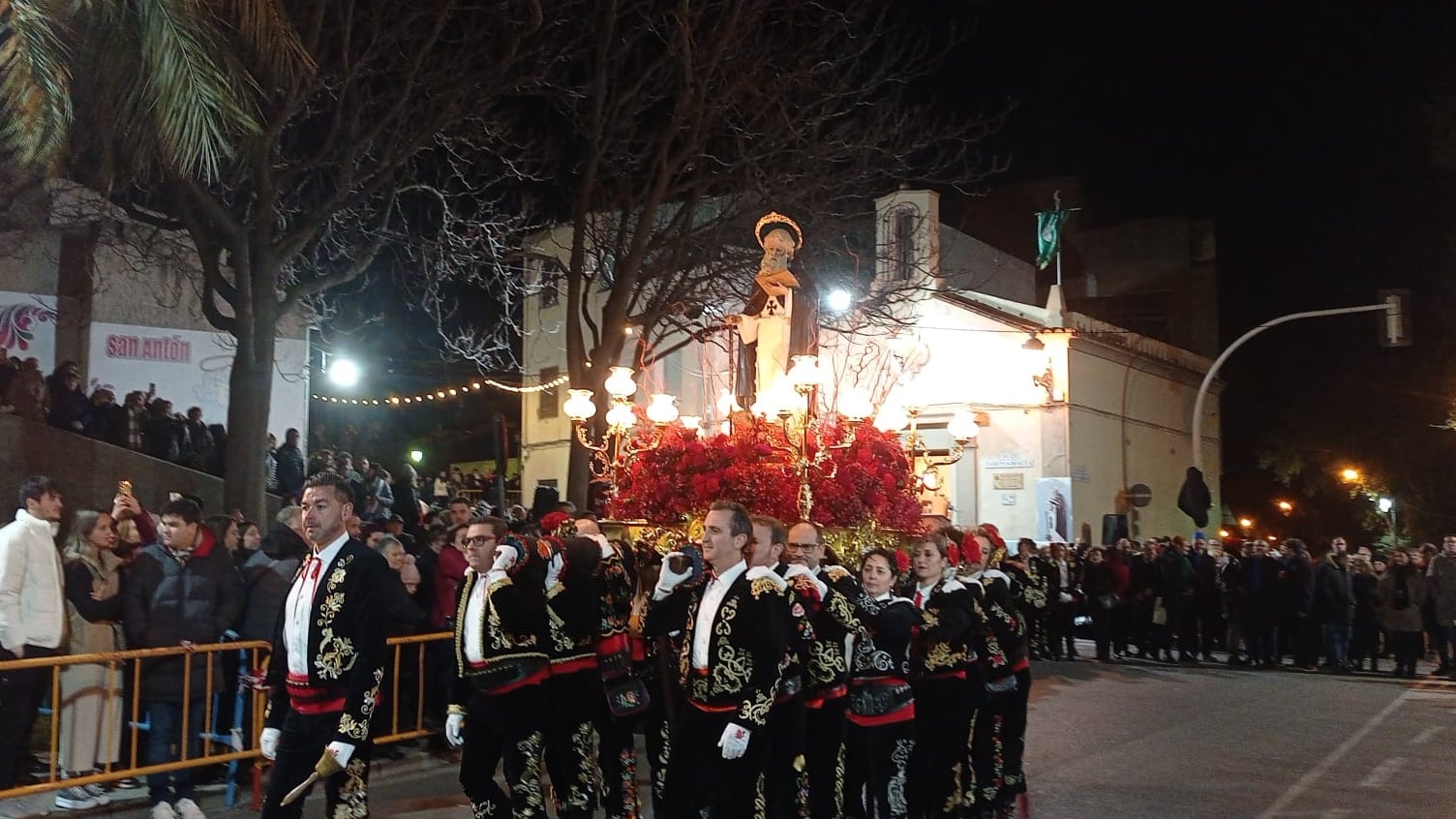 La figura de San Antón, siendo llevada a hombros por Contrabandistas bajo la antenta mirada de los ciudadanos