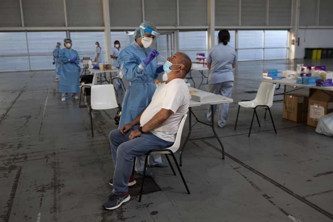 A health worker does a PCR test on a patient