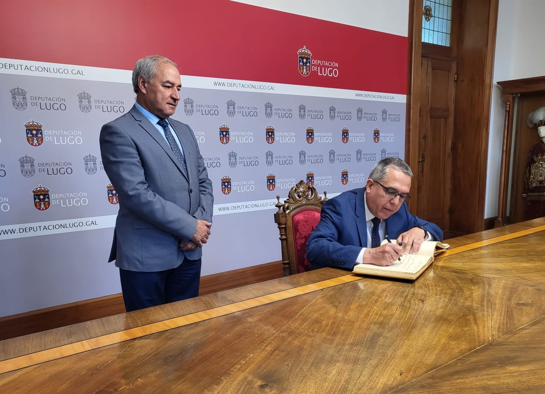 El embajador cubano, Marcelino Medina, firma el libro de oro de la Diputación de Lugo en compañía de Tomé, presidente de la institución provincial