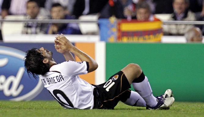 El centrocampista argentino del Valencia C.F. Éver Banega cae al suelo lesionado durante el partido correspondiente a la cuarta jornada de la Fase de grupos de la Liga de Campeones contra el Bayer Leverkusen