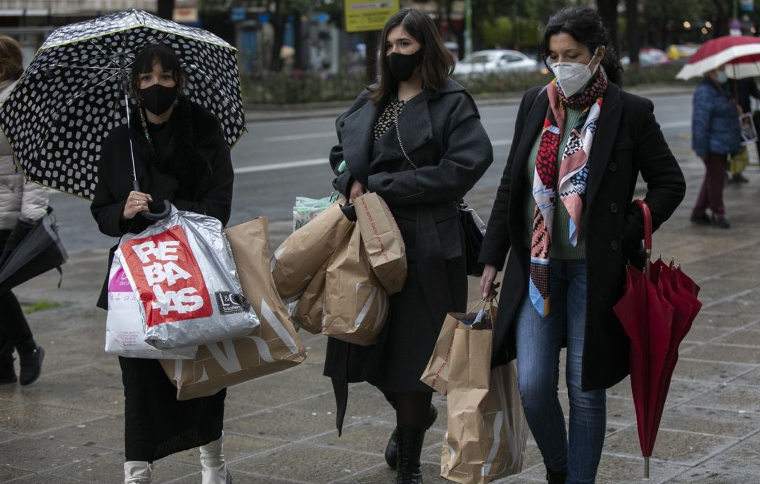 Varias personas cargadas de bolsas durante el comienzo de las rebajas de invierno