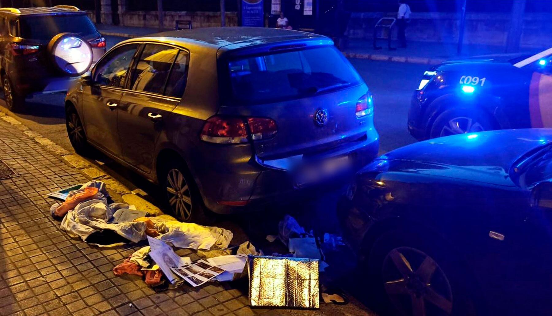 Uno de los vehículos afectados con los objetos en su interior esparcidos por el suelo