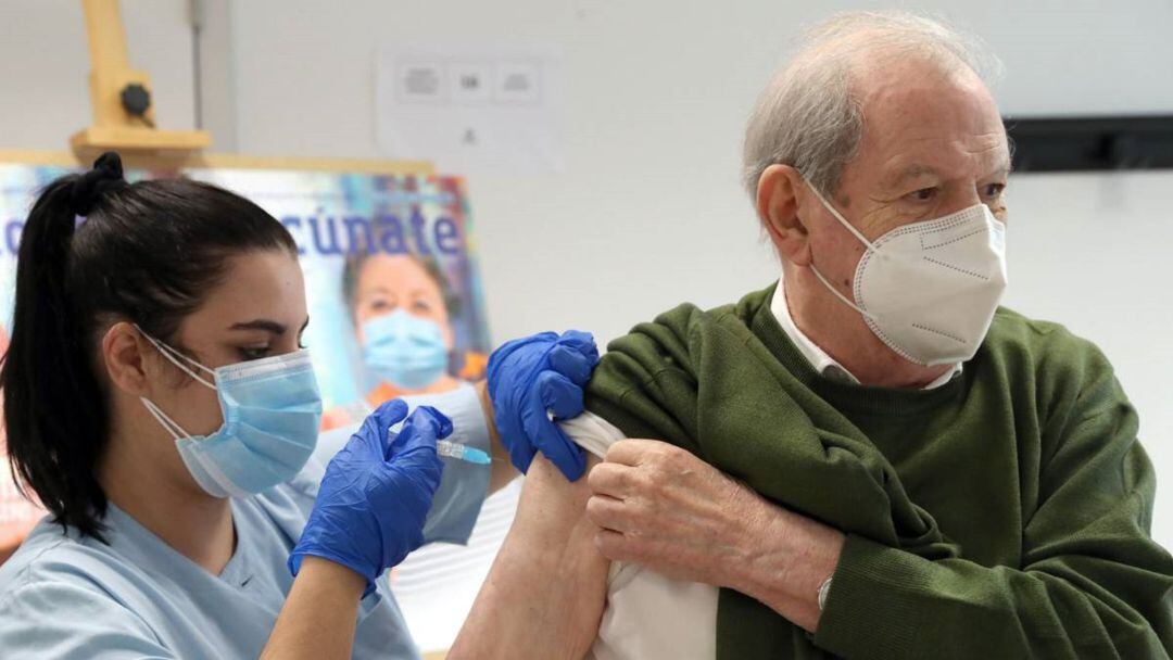 Una enfernera inocula la vacuna de la gripe a un hombre.